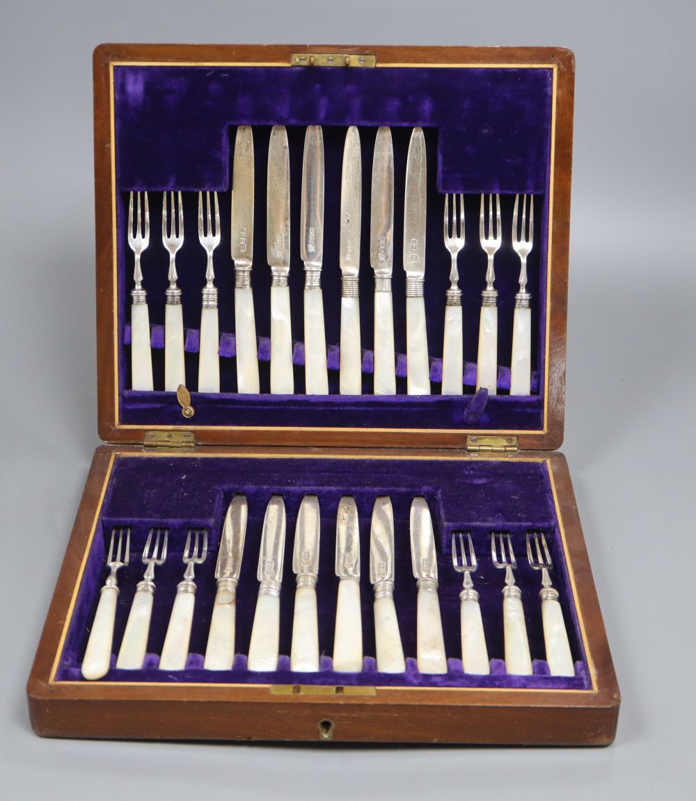 A cased set of twelve mother of pearl handled silver deseert knives and eleven forks, F. Asman & Co, Sheffield, 1908/10,